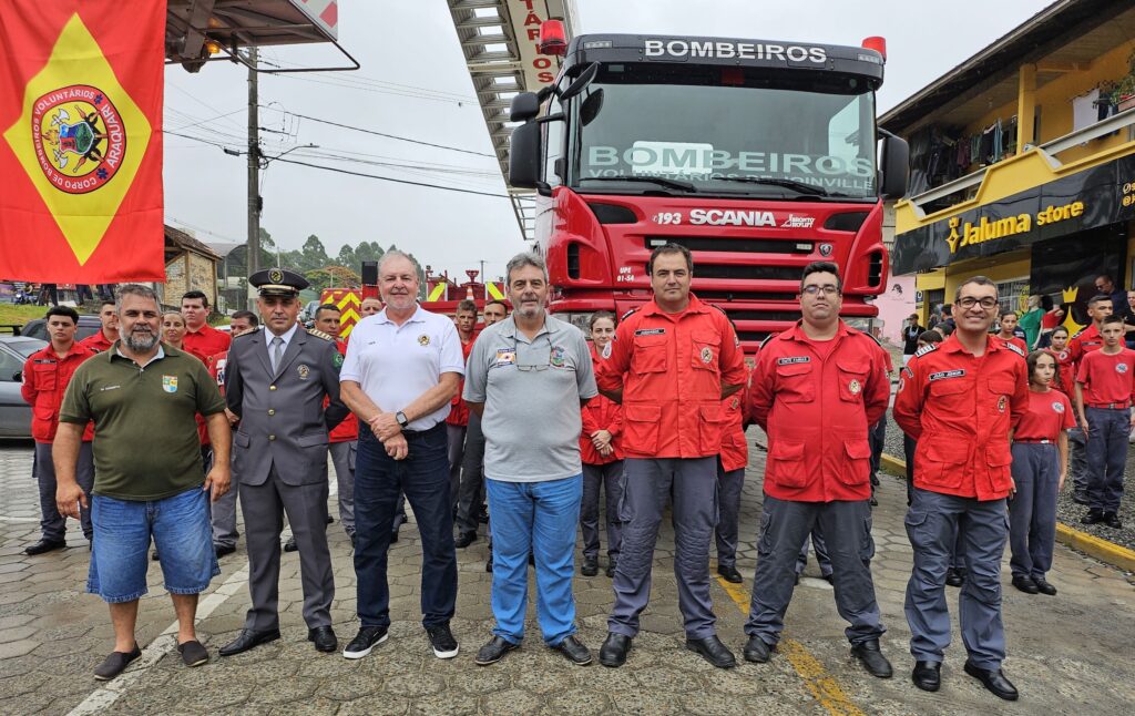 Bombeiros voluntários perfilados na frente da plataforma elevatória dos Bombeiros Voluntários de Joinville.